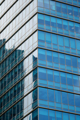 Fototapeta premium Modern Glass Office Building Facade with Reflective Windows.
