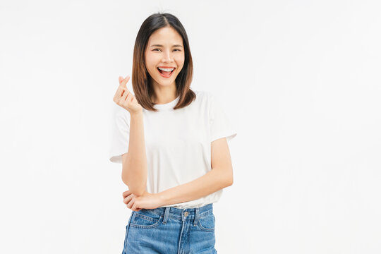 Happy young Asian woman making finger heart gesture and smiling isolated on white studio background.