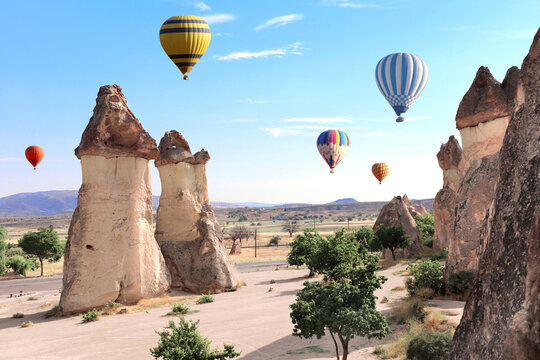 Balloon flight, famous tourist attraction of Cappadocia. Air balloons and Fairy Chimney in Pasabag Valley, Anatolia, Turkey. Popular destination for travellers seeking an adventure and natural beauty
