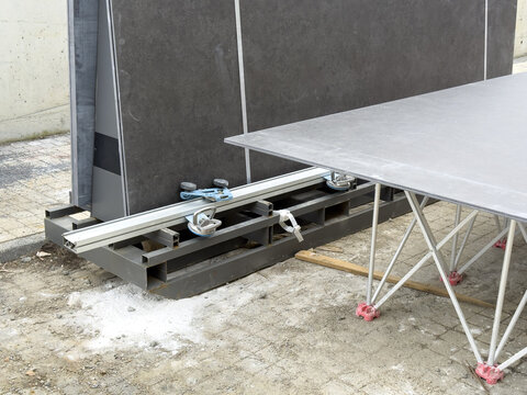 View of large porcelain slabs being moved with vacuum suction lifters on a metal transport rack at a construction site Sariyer, Istanbul, Turkiye.