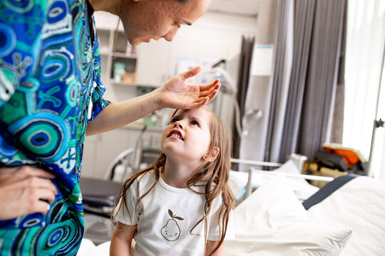 Healthcare worker comforting child in hospital room