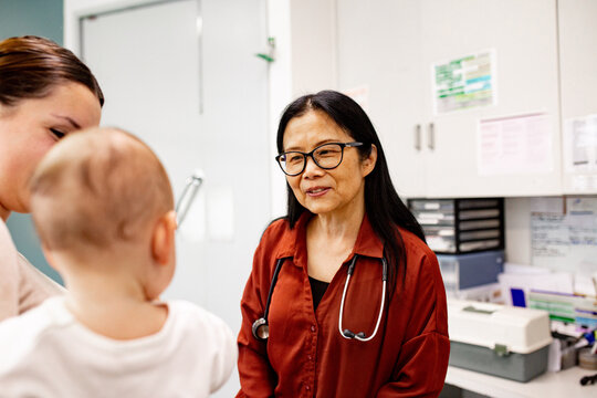 Parent with baby speaking to doctor in clinic