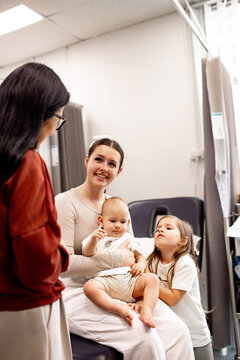 Healthcare professional engaging with parent, baby and child