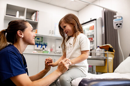 Aboriginal medical professional examining a child&rsquo;s wrist in a clinic