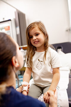 A female nurse comforting a child patient in clinic
