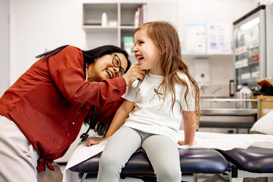 Otolaryngologist examining a child&rsquo;s ear with an otoscope in a clinic