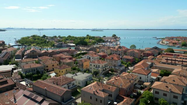 Aerial view of colorful Murano rooftops and canals near Venetian lagoon on a sunny day