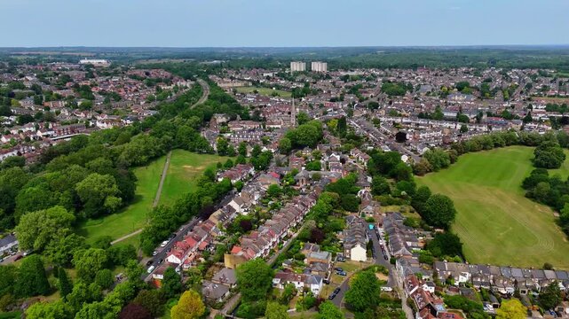 Aerial wide shot panning across Enfield Town, London, with houses and green parks