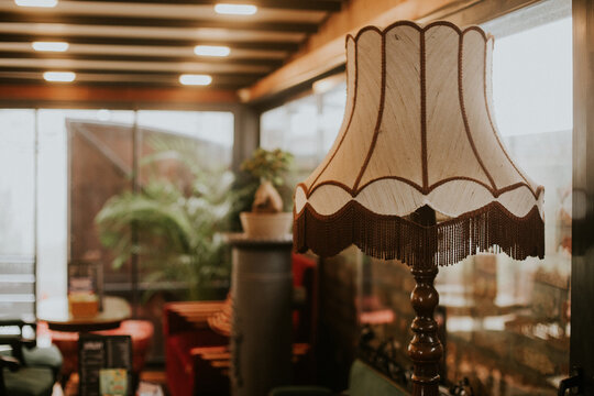 View of a vintage floor lamp with a fringed shade in a cozy interior with wooden ceiling beams and warm lighting Sremska Mitrovica, Vojvodina, Serbia.