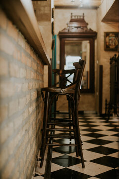 View of the interior of a rustic bar featuring a brick wall, wooden counter, and checkered tile floor in Sremska Mitrovica, Vojvodina, Serbia.