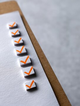 Paper with multiple orange checkmarks on a board
