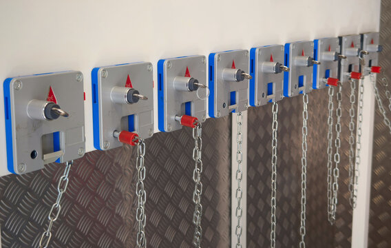 Row of supermarket trolley locking devices with keys and metal security chains