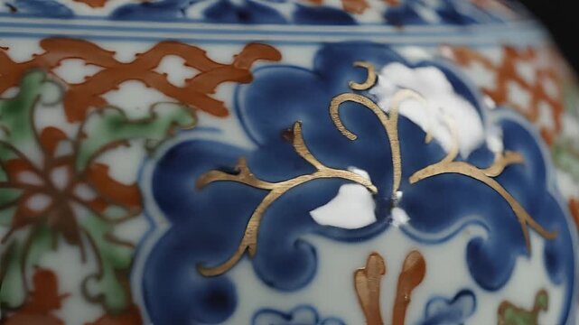 Closeup of an antique porcelain vase with intricate floral patterns and gold accents.