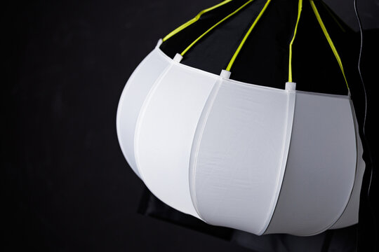 Spherical lantern softbox modifier on a dark studio background.