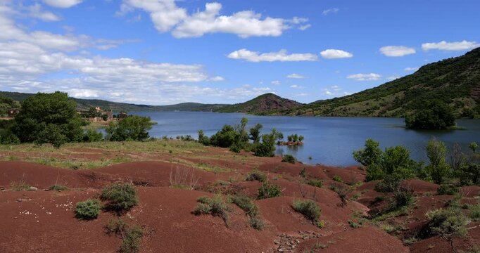 Red landscape surrounding te artificial lake of Salagou, Occitania, Southern France.