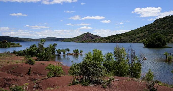 Red landscape surrounding te artificial lake of Salagou, Occitania, Southern France.