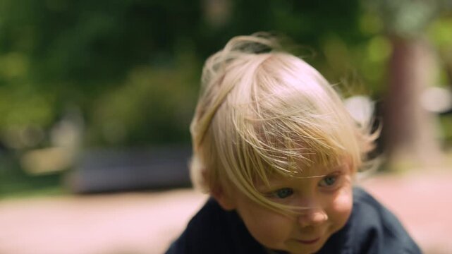 Young blonde child with playful windtousled hair and cheerful expression