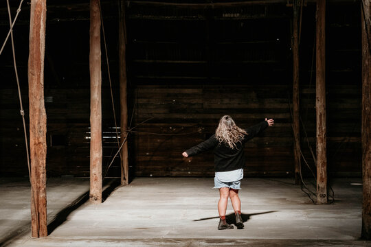 Middle age woman dancing inside historic building in sunlight