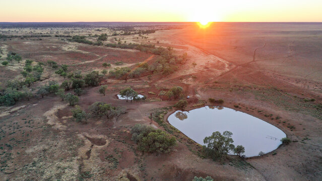Drone shot of a dam and creek on sunrise