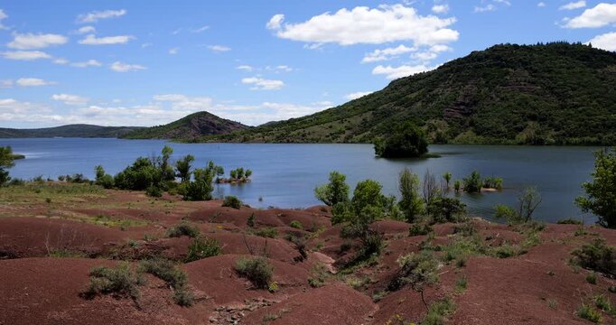Red landscape surrounding te artificial lake of Salagou, Occitania, Southern France.