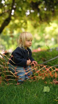 Young girl with light hair investigates colorful fencing