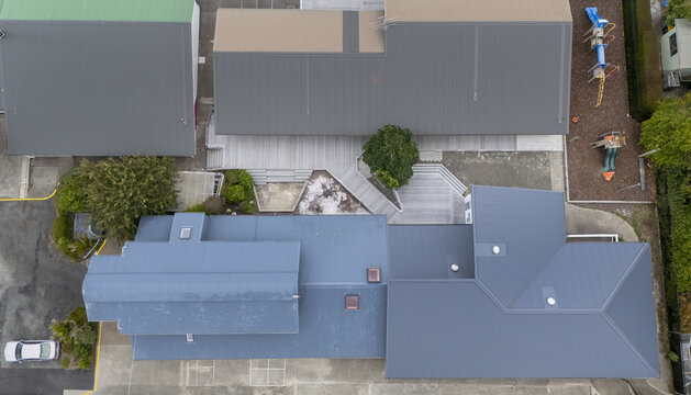 Aerial view of the buildings and playground at Marybank featuring modern metal roofs, a recycled plastic deck, and outdoor play equipment in Nelson, Nelson Region, New Zealand.