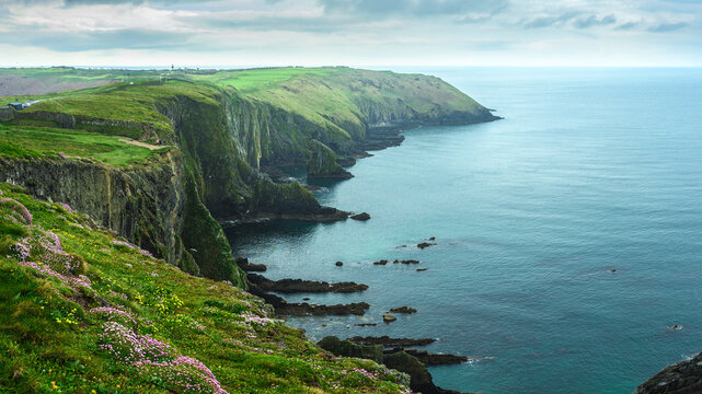 Dramatic sea cliffs at the Old Head of Kinsale at rain with misty Atlantic views, County Cork, Ireland.