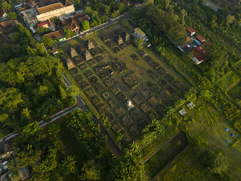 Aerial view of Plaosan Kidul Temple featuring ancient stone ruins and stupas surrounded by lush green trees and village houses Kecamatan Prambanan, Jawa Tengah, Indonesia.