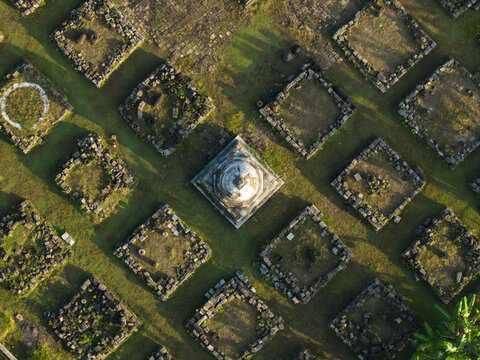 Aerial view of Plaosan Kidul Temple with its symmetrical stone foundations and central stupa surrounded by green grass in Kecamatan Prambanan, Jawa Tengah, Indonesia.