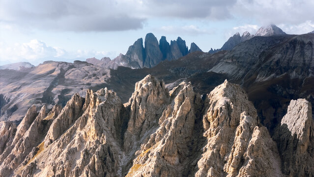 Aerial view of the jagged peaks and rocky ridges of Gardena Pass under a cloudy sky in Corvara, Trentino-Alto Adige S, Italy.