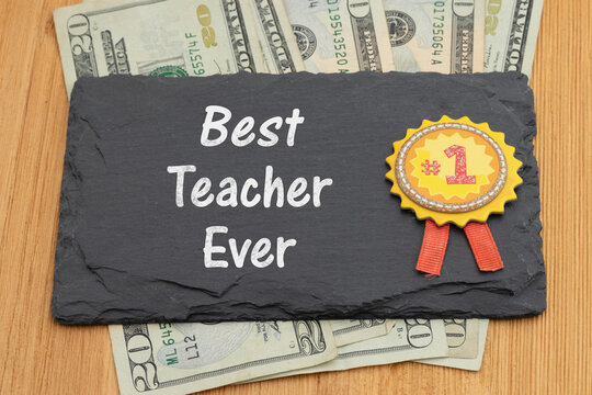 Best Teacher Ever text on chalkboard with number one ribbon and money on wood desk