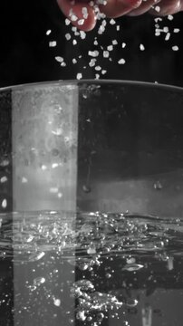 The cook salts the water in a saucepan. Filmed on a high-speed camera at 1000 fps. High quality FullHD footage