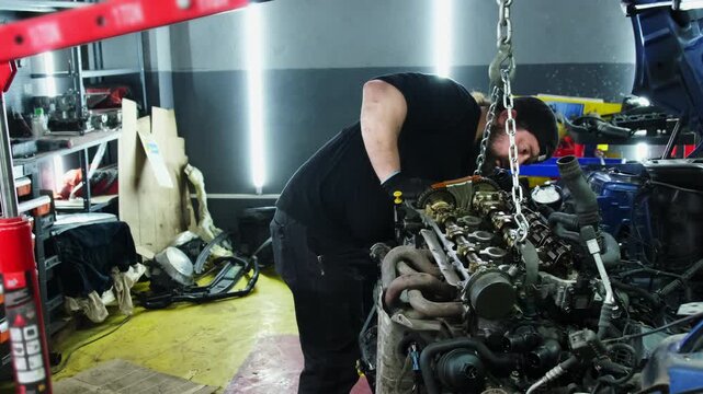 Specialist performs analysis of engine condition during shift. Man in protective glove inspects system components assessing extent of damage
