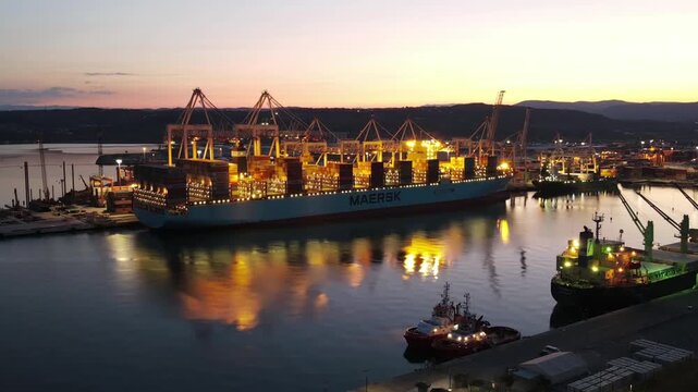 Early dawn timelapse over yellow lit cargo operations