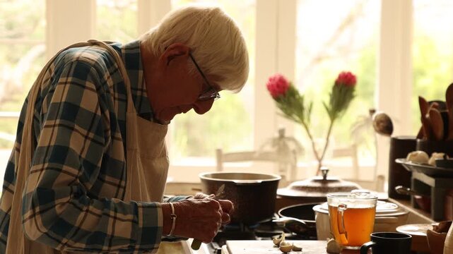 elderly man preparing a pot roast in his kitchen