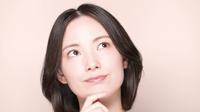美容やセルフケアをどうしようか迷う、考え事をする若い女性の動画