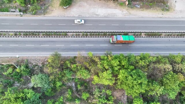Birds eye Drone tracking commercial freight truck on scenic mountain road.  Truck driving on rugged national highway.
