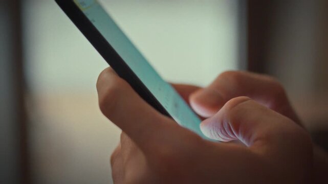 A man carefully taps the touch keyboard on his smartphone, typing into the notes application. His fingers press each letter distinctly, showcasing digital tools for instant thought capture