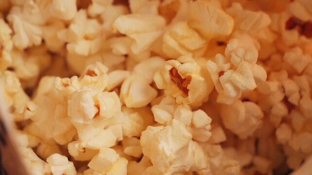 Close-up of ready popcorn in a paper bucket, popcorn texture background. High quality 4k footage