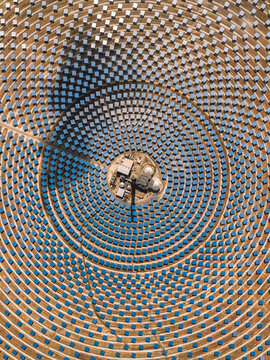 Aerial view of Torresol Energy Gemasolar plant with concentric circles of blue heliostats reflecting the sky on arid ground in Fuentes de Andalucia, Andalucia, Spain.