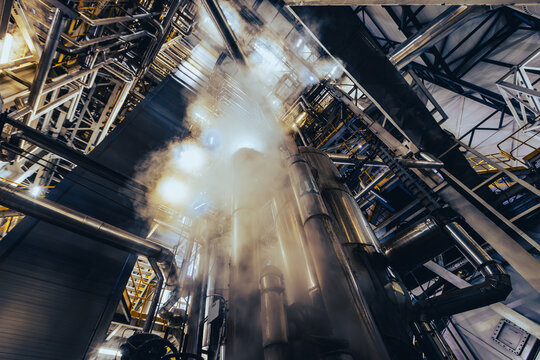 Industrial pipes and steel tanks with rising steam