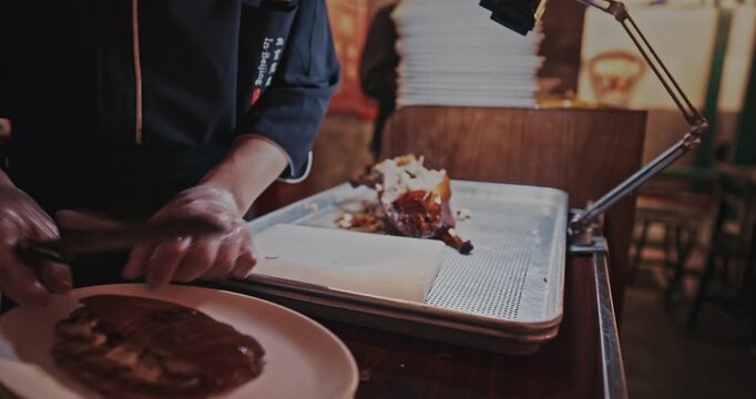 chef skillfully Peking duck slices succulent meat for an eager crowd, showcasing
