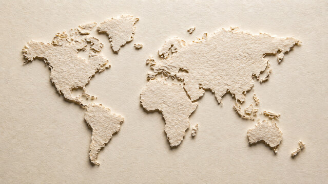 Flat lay of world map cutout made of rough paper texture on ivory colored paper background