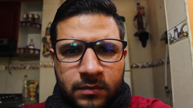 A digital content creator wearing glasses is speaking to the camera and then cleans the lens because it's dirty. Concept of user-generated content and technology
