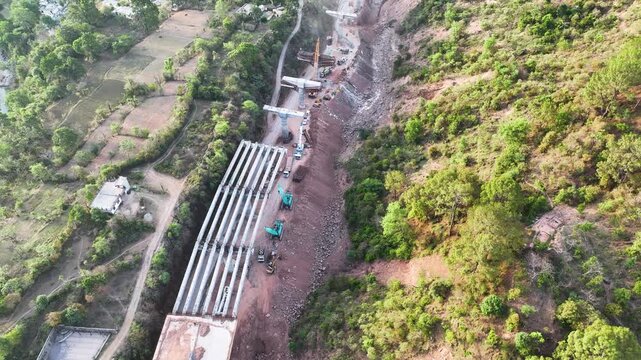 Active bridge construction and heavy machinery in Mountainous Rural Indian terrain.