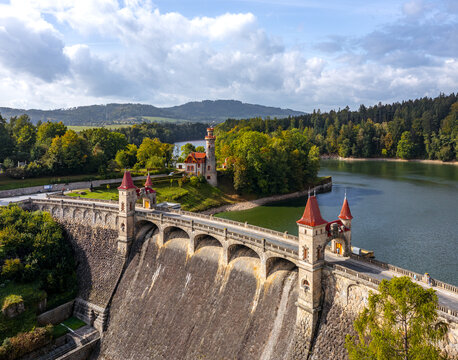 Aerial view of the Royal Forest Dam featuring its fairy-tale stone towers with red roofs and the surrounding reservoir and lush forest in Bila Tremesna, Hradec Kralove Region, Czechia.