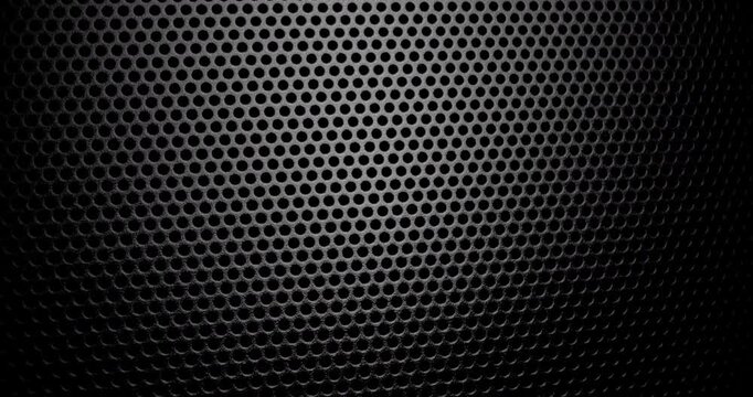 Black Perforated Metal Mesh. Smooth slow movement across extreme close-up of dark perforated metal grid with dramatic side lighting.	