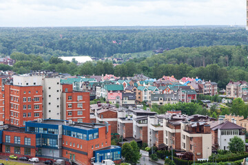 Fototapeta premium Suburban residential neighborhood with townhouses and green forest landscape