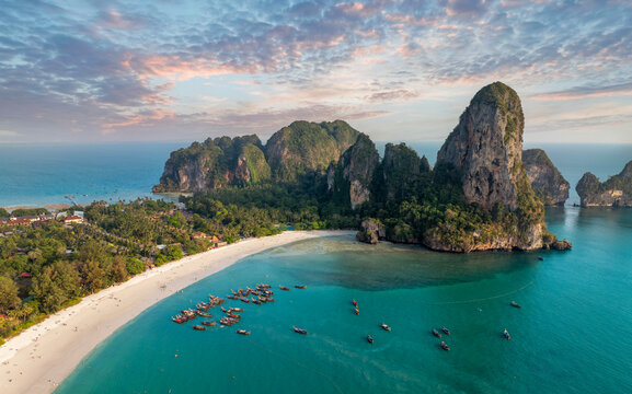 Railay Beach, Krabi, Thailand Beautiful beach and sea of Thailand at sunset Aerial view of Railay Beach, tourists and long-tail boats, lush rainforest and emerald sea
