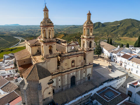 Aerial view of the Parish of Our Lady of the Incarnation with its twin towers and the surrounding white-washed houses and rolling hills in Olvera, Andalusia, Spain.